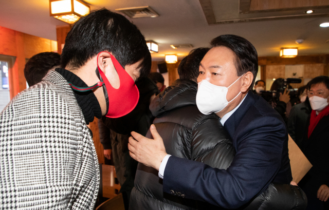 국민의힘 윤석열 대선 후보가 2일 오후 서울 종로구 한 음식점에서 열린 코로나19 자영업 피해 현장 간담회에서 자영업자들을 위로하고 있다. 연합뉴스