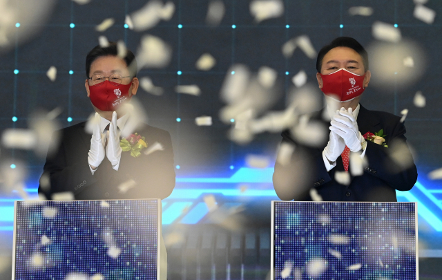 더불어민주당 이재명 대선 후보와 국민의힘 윤석열 대선 후보가 3일 오전 서울 여의도 한국거래소에서 열린 2022년 증권·파생상품시장 개장식에서 참석자들과 함께 개장 신호 버튼을 누른 뒤 박수를 치고 있다. 연합뉴스