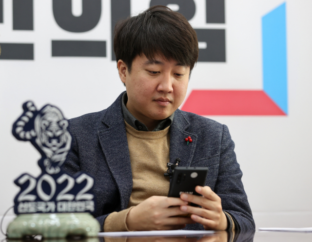 국민의힘 이준석 대표가 3일 오전 서울 여의도 국회에서 2022년 신년인사회를 준비하며 신지예 시대준비위원회 수석부위원장의 사퇴소식을 접하고 있다. 연합뉴스