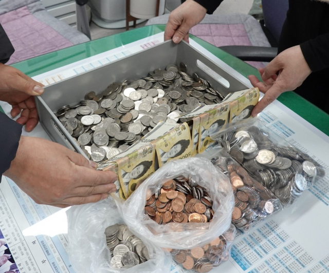 환경공무직 퇴직한 마덕경(59) 씨가 기탁한 565,540원의 동전과 지폐 사진. 달서구청 제공