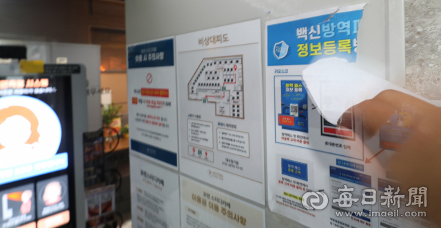 5일 오후 대구 서구의 한 스터디카페에서 한 관계자가 입구에 붙은 백신 방역패스 안내문구를 떼어내고 있다. 전날 법원은 학원 및 독서실 등 교육시설에 대한 방역패스 효력 정지 결정을 내렸다. 안성완 기자 asw0727@imaeil.com