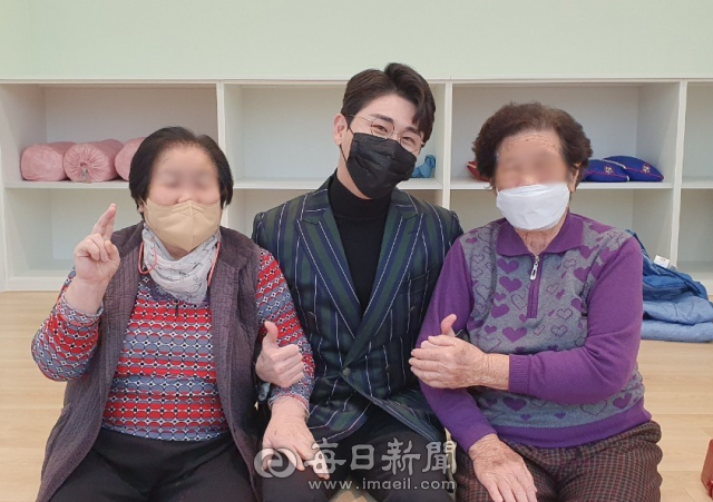 가수 영탁이 지난달 31일 경북 안동지역 한 노인복지센터를 방문해 자신의 팬인 어르신들과 만나 기념촬영을 하고 있다. 안동주간보호센터 제공