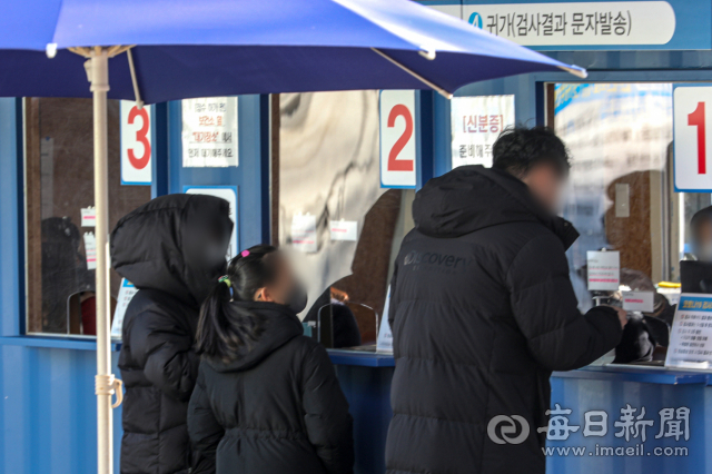 6일 오후 대구 달서구보건소 코로나19 선별진료소를 찾은 한 어린이가 코로나19 진단검사를 받기 위해 부모님과 함께 문진표를 접수하고 있다. 안성완 기자 asw0727@imaeil.com
