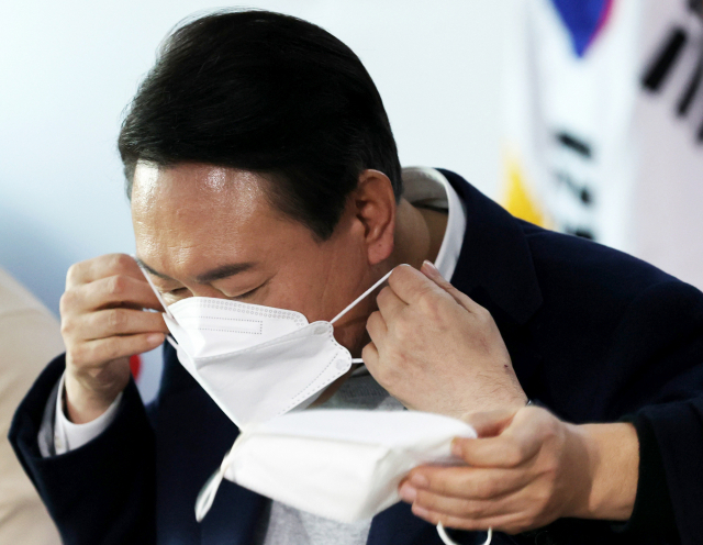 국민의힘 윤석열 대선 후보가 6일 오후 서울 여의도 당사에서 청년보좌역들과 간담회를 하던 중 마스크를 교체하고 있다. 연합뉴스