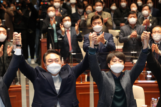 극한 대치 끝에 전격 화해한 국민의힘 윤석열 대선 후보와 이준석 대표가 6일 저녁 국회에서 열린 의원총회에서 손을 맞잡고 있다. 연합뉴스
