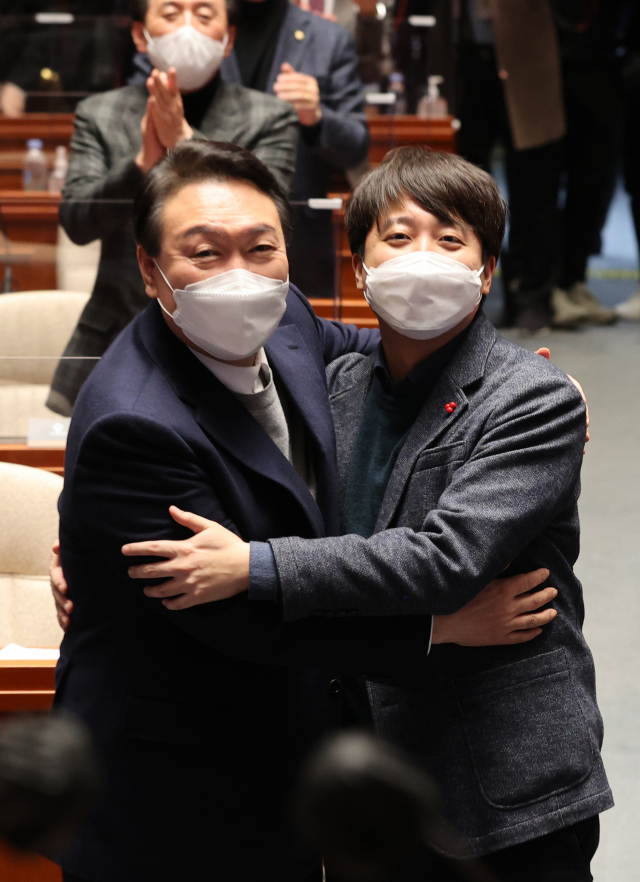 극한 대치 끝에 전격 화해한 국민의힘 윤석열 대선 후보와 이준석 대표가 6일 저녁 국회에서 열린 의원총회에서 포옹하고 있다. 연합뉴스