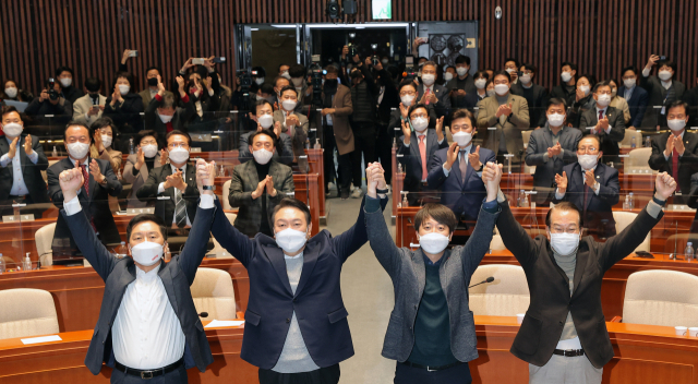 극한 대치 끝에 전격 화해한 국민의힘 윤석열 대선 후보와 이준석 대표가 6일 저녁 국회에서 열린 의원총회에서 두 팔을 들어 올리고 있다. 왼쪽부터 김기현 원내대표, 윤 후보, 이 대표, 권영세 사무총장. 연합뉴스