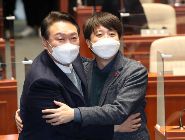 극한 대치 끝에 전격 화해한 국민의힘 윤석열 대선 후보와 이준석 대표가 6일 저녁 국회에서 열린 의원총회에서 손을 맞잡고 있다. 연합뉴스