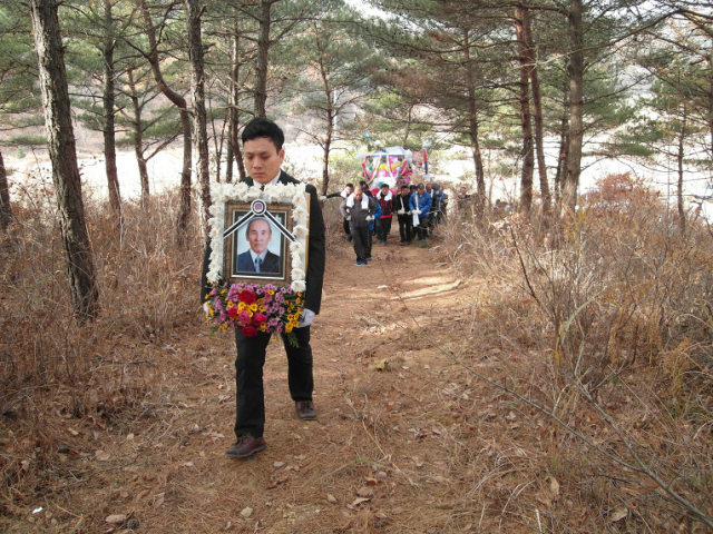 전형무 씨가 할아버지를 보내드리기 위해 영정사진을 들고 산소로 이동하고 있다. 가족제공.