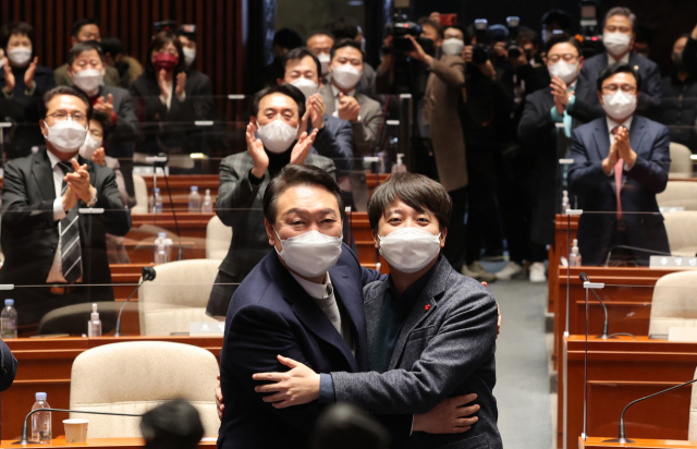 극한 대치 끝에 전격 화해한 국민의힘 윤석열 대선 후보와 이준석 대표가 6일 저녁 국회에서 열린 의원총회에서 포옹하고 있다. 연합뉴스