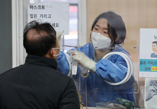 신종 코로나바이러스 감염증(코로나19) 신규 확진자 수가 3천376명을 기록한 9일 오전 서울 중구 서울역 임시 선별검사소에서 의료진이 시민의 검체를 채취하고 있다. 연합뉴스