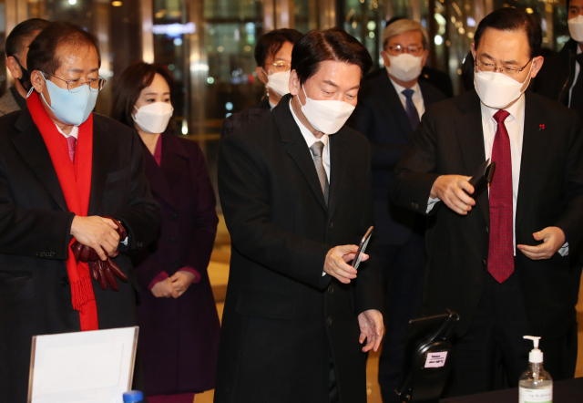 국민의당 안철수 대선후보와 국민의힘 홍준표, 주호영 의원이 3일 오후 대구 북구 인터불고 호텔 입구에서 QR코드를 찍고 있다. 연합뉴스