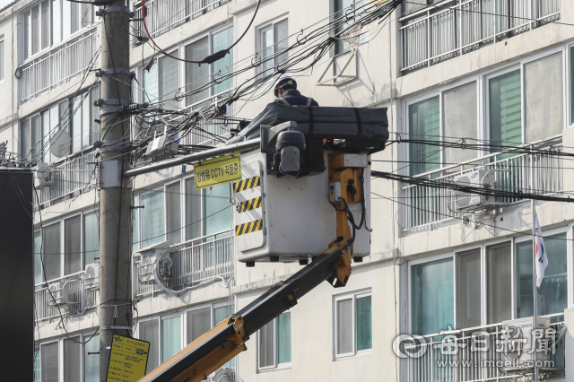 지난 10일 대구 시내 한 주택가에서 근로자가 작업용 특수차량에 올라 공중선 정비 작업을 하고 있다. 우태욱 기자 woo@imaeil.com