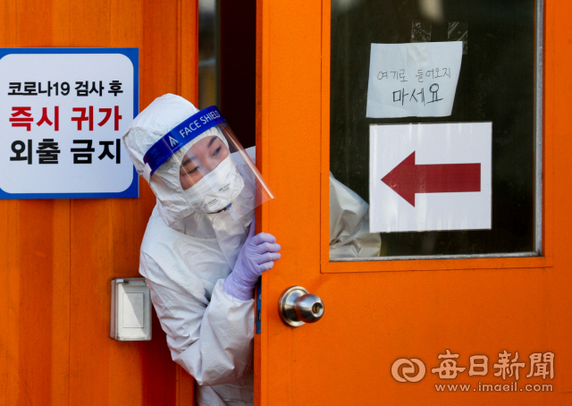 11일 대구 달서구보건소 선별검사소에서 간호사가 검체 채취 부스 안에서 추위를 녹이고 있다. 대구시는 오미크론 변이가 이달 말이나 다음달 초 우세종이 될 것으로 보고 확진자 급증에 대비해 병상확보와 재택치료 확대 등 방역대책 마련에 힘을 쏟고 있다. 매일신문 DB.