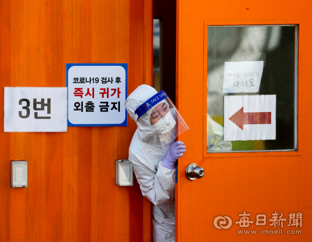 11일 대구 달서구보건소 선별검사소에서 간호사가 검체 채취 부스 안에서 추위를 녹이고 있다. 대구시는 오미크론 변이가 이달 말이나 다음달 초 우세종이 될 것으로 보고 확진자 급증에 대비해 병상확보와 재택치료 확대 등 방역대책 마련에 힘을 쏟고 있다. 우태욱 기자 woo@imaeil.com