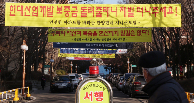16일 안양 관양동 현대아파트 입구에 재건축 관련 현수막이 붙어 있다. 재건축조합, 건설사 현수막 사이로 현대산업개발 반대 내용을 담은 한 단체의 현수막이 보인다. 이날 한 조합원은