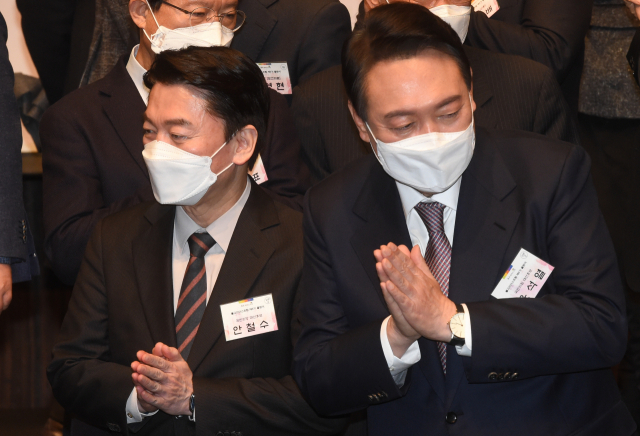 국민의힘 윤석열 대선 후보와 국민의당 안철수 대선 후보가 17일 오후 서울 중구 신라호텔에서 열린 불교리더스포럼 제5기 출범식에서 기념 촬영을 한 뒤 합장하고 있다. 연합뉴스