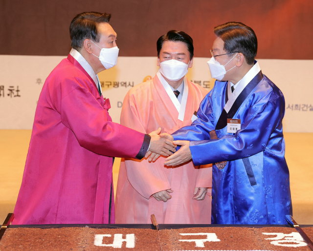 더불어민주당 이재명(오른쪽부터)·국민의당 안철수·국민의힘 윤석열 대선후보가 17일 서울 중구 프레스센터에서 열린 재경 대구경북인 신년교례회에 참석해 인사하고 있다. 연합뉴스