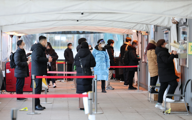 신종 코로나바이러스 감염증 신규 확진자 수가 4천72명을 기록한 18일 오전 서울시청 앞 코로나19 임시선별진료소를 찾은 시민들이 검사를 위해 줄을 서 있다. 연합뉴스