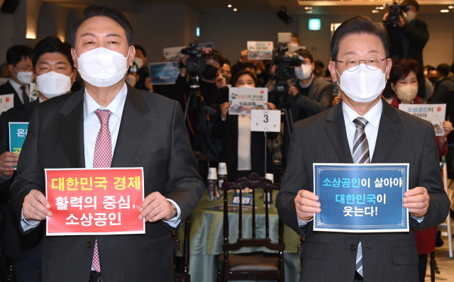 더불어민주당 이재명(오른쪽) 대선후보와 국민의힘 윤석열 대선후보가 18일 서울 여의도 CCMM빌딩에서 열린 소상공인연합회 신년 하례식에 참석, 손팻말을 들고 기념촬영을 하고 있다. 연합뉴스
