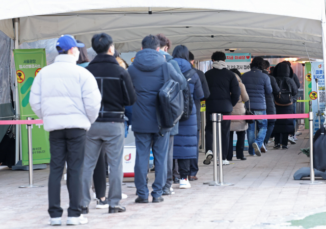 18일 오전 서울시청 앞 코로나19 임시선별진료소를 찾은 시민들이 검사를 위해 줄을 서 있다. 연합뉴스