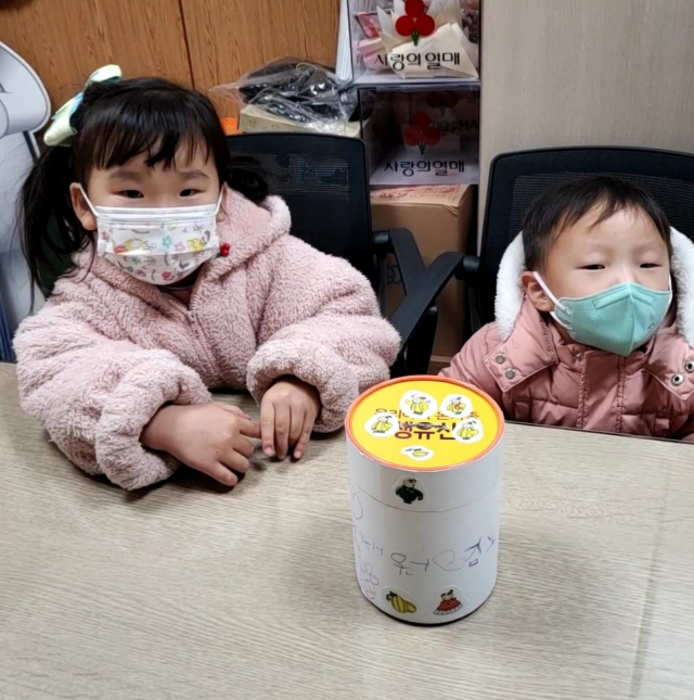 성주군 김채원(6·왼쪽), 도경(5) 남매와 이들이 지난 한 해 동안 용돈을 모았던 저금통. 성주군 제공