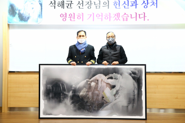 석해균(왼쪽) 선장이 곽호철 작가의 작품을 받은 뒤 곽 작가와 함께 기념촬영을 하고 있다. 칠곡군 제공