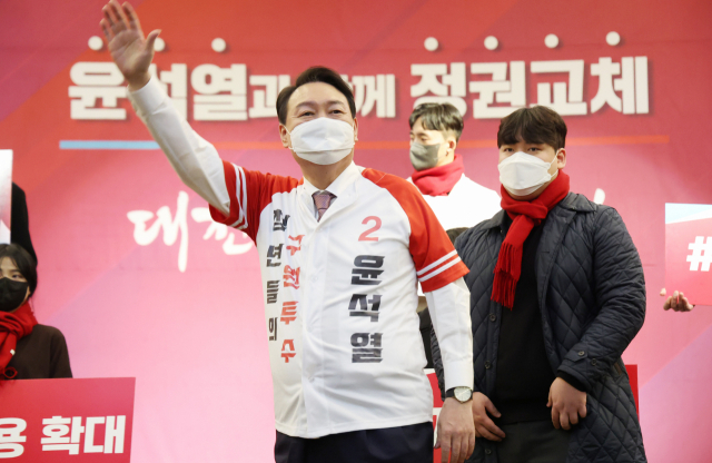 국민의힘 윤석열 대선 후보가 21일 오후 대전 서구 오페라웨딩홀에서 열린 대전 선대위 필승결의대회에서 청년 당원으로부터 전달받은 