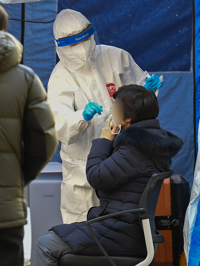 대구지역 코로나19 신규 확진자 수가 388명으로 집계된 지난 21일 오후 대구 북구보건소 선별진료소에서 한 시민이 코로나19 유전자증폭(PCR) 검사를 받고 있다. 김영진 기자 kyjmaeil@imaeil.com