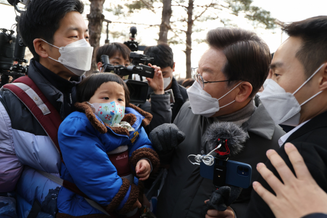 더불어민주당 이재명 대선후보가 22일 서울시 송파구 석촌호수에서 지지자들과 인사하며 이동하고 있다. 연합뉴스