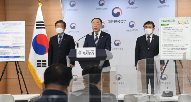홍남기 경제부총리 겸 기획재정부 장관(가운데)이 21일 정부서울청사에서 권덕철 보건복지부 장관(오른쪽)과 권칠승 중소벤처기업부 장관이 참석한 가운데 2022년 추가경정예산안에 대해 브리핑을 하고 있다. 연합뉴스