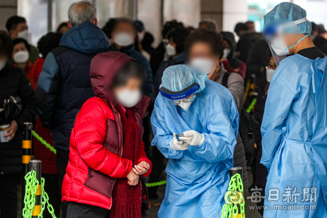 24일 오전 대구 북구보건소 코로나19 선별진료소에서 관계자가 시민에게 PCR검사 절차를 설명하고 있다. 정부는 이날 오미크론 변이가 우세종이 됨에 따라 방역체계를 