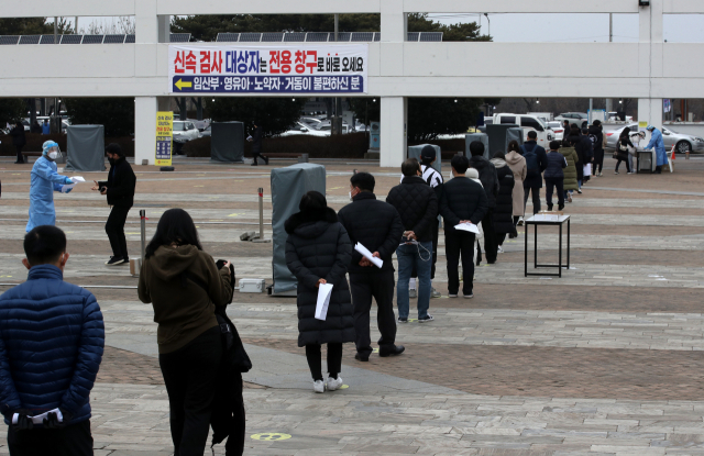 24일 오후 광주시청 광장에 마련된 임시선별검사소에서 코로나19 검사를 받으려는 시민들이 길게 줄 서 있다. 오미크론이 우세한 광주, 전남, 평택, 안성 등 4개 지역에서는 이달 26일부터 코로나19 유전자증폭 검사를 밀접접촉자, 60세 이상 고령층 등 고위험군만 받을 수 있다. 유증상자를 포함한 그 외 대상자는 선별진료소에서 자가검사키트로 검사를 한 뒤, 양성이 나오면 PCR 검사를 받게 된다. 연합뉴스