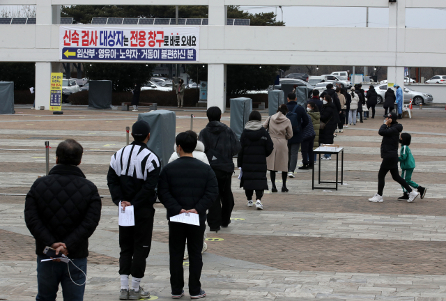 24일 오후 광주시청 광장에 마련된 임시선별검사소에서 코로나19 검사를 받으려는 시민들이 길게 줄 서 있다. 오미크론이 우세한 광주, 전남, 평택, 안성 등 4개 지역에서는 이달 26일부터 코로나19 유전자증폭 검사를 밀접접촉자, 60세 이상 고령층 등 고위험군만 받을 수 있다. 유증상자를 포함한 그 외 대상자는 선별진료소에서 자가검사키트로 검사를 한 뒤, 양성이 나오면 PCR 검사를 받게 된다. 연합뉴스