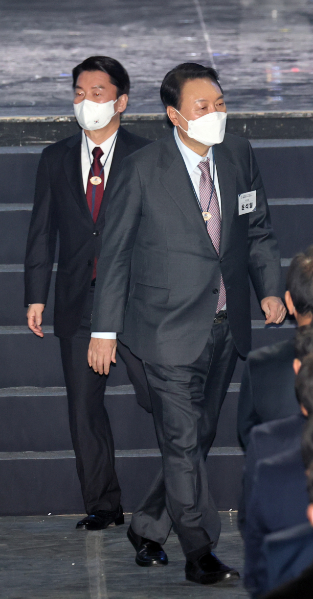 국민의힘 윤석열 대선 후보와 국민의당 안철수 대선 후보가 25일 오후 서울 송파구 올림픽홀에서 열린 2022 제24회 베이징 동계올림픽 선수단 결단식에서 기념촬영을 한 뒤 무대를 내려가고 있다. 연합뉴스