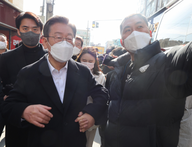 더불어민주당 이재명 대선 후보가 27일 광주시 서구 광주화정아이파크 붕괴사고 현장을 방문, 실종자 6명의 가족 대표인 안정호 씨의 손을 잡고 있다. 연합뉴스