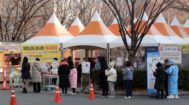 국내 신규 확진자 수가 연일 최다기록을 쓰고 있는 가운데 27일 부산 연제구보건소 선별진료소에서 코로나19 검사를 받기 위해 시민들이 차례를 기다리고 있다. 연합뉴스