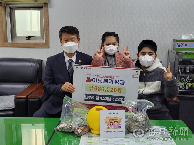 경산초등학교 재학중인 김이스마일, 김소피아 남매가 68만6천520원의 이웃돕기 성금을 이상철 경산시 남부동장에게 기탁했다. 경산시 제공.