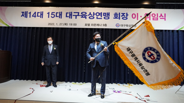 노기원 대구육상연맹 신임 회장이 27일 대구 호텔 라온제나에서 열린 회장 이·취임식에 참석, 최영수 전임 회장으로부터 연맹기를 넘겨받아 힘차게 휘두르고 있다. 태왕 제공