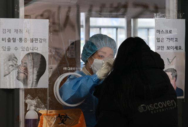 설 연휴 첫날인 29일 오전 서울 중구 서울역 광장 코로나19 임시 선별검사소에서 의료진이 검체 채취를 하고 있다. 연합뉴스