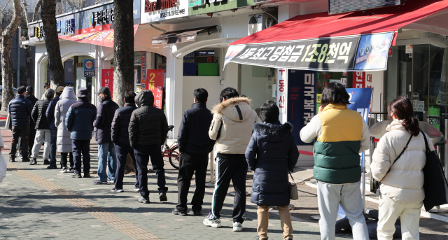설 연휴를 하루 앞둔 28일 노원구 한 로또 판매점에 시민들이 줄지어 서 있다. 이번 주 로또는 1000회 추첨이다. 연합뉴스
