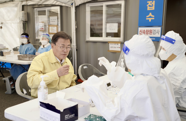 문재인 대통령이 설 연휴인 30일 경부고속도로 안성휴게소(서울방향)에 설치된 코로나19 임시선별검사소를 방문, 신속항원검사 키트를 직접 사용해보고 있다. 연합뉴스