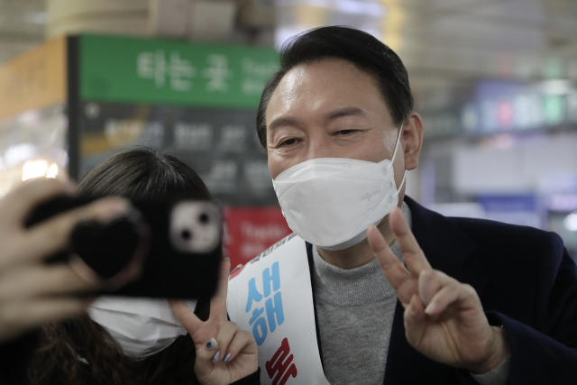 국민의힘 윤석열 대선 후보가 설 연휴 첫날인 29일 서울 강남역을 찾아 시민들에게 새해 인사를 하며 기념촬영을 하고 있다. 연합뉴스