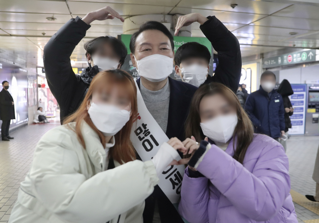 국민의힘 윤석열 대선 후보가 설 연휴 첫날인 29일 서울 강남역을 찾아 시민들에게 새해 인사를 하며 기념촬영을 하고 있다. 연합뉴스