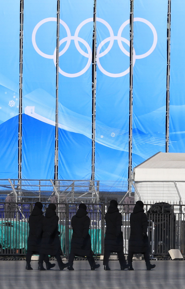 2022 베이징 동계올림픽 개막을 이틀 앞둔 2일 오전 베이징 국립 경기장 인근에 설치된 올림픽 조형물 앞으로 보안요원이 이동하고 있다. 이번 대회는 코로나19 확산을 막기 위해 선수단, 취재진 및 대회 관계자들은 대회 전용 교통편을 통해서 정해진 경로로만 이동할 수 있다. 연합뉴스