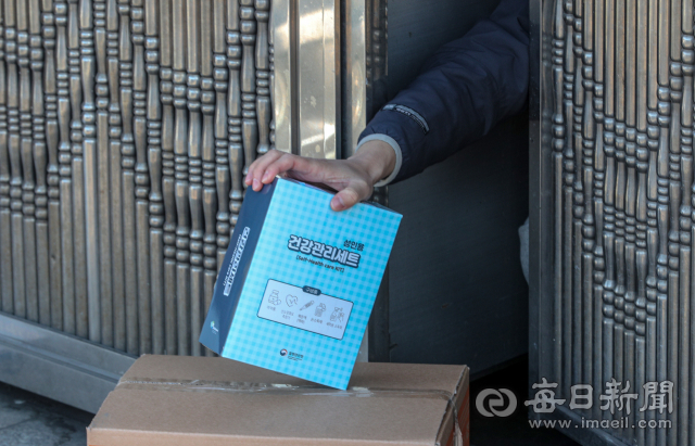코로나19 신규 확진자가 이틀 연속 2만 명을 돌파한 3일 오후 대구 시내의 한 재택치료 중인 확진자가 집 앞에 놓인 재택치료 키트를 수령하고 있다. 이날 0시 기준 대구지역 재택치료자는 5천 789명을 기록했다. 안성완 기자 asw0727@imaeil.com