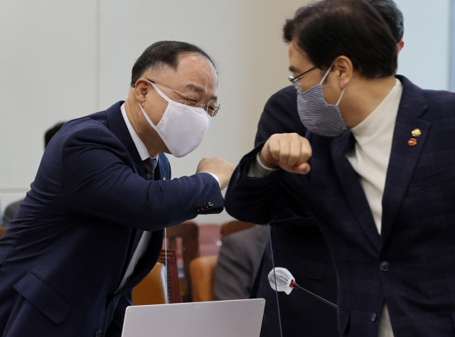 홍남기 부총리 겸 기획재정부 장관이 4일 오전 국회에서 열린 기획재정위원회 전체회의에서 더불어민주당 우원식 의원과 팔꿈치 인사를 하고 있다. 연합뉴스