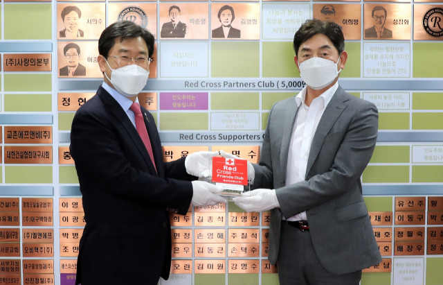 대한적십자사 대구광역시지사 송준기(왼쪽) 회장이 동보정보통신(주) 대표 김기범에게 특별성금 기부를 기념한 레드크로스 프렌드클럽 명패를 전달하고 있다.