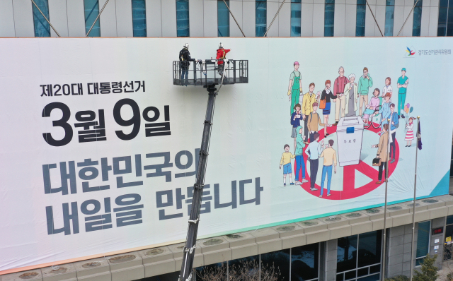 제20대 대통령선거를 30일 앞둔 7일 오후 경기도 수원시 경기도선거관리위원회에서 관계자들이 청사 외벽에 투표 참여 홍보 현수막을 설치하고 있다. 연합뉴스