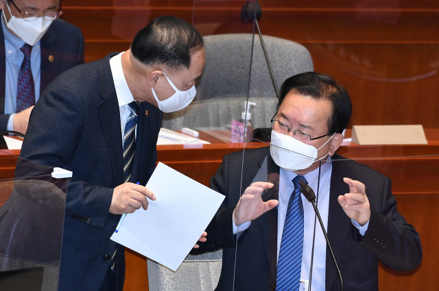 김부겸 국무총리(오른쪽)와 홍남기 경제부총리 및 기획재정부 장관이 8일 서울 여의도 국회에서 열린 예산결산특별위원회에서 대화하고 있다. 연합뉴스